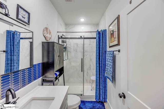 bathroom with vanity, toilet, and a shower with shower door