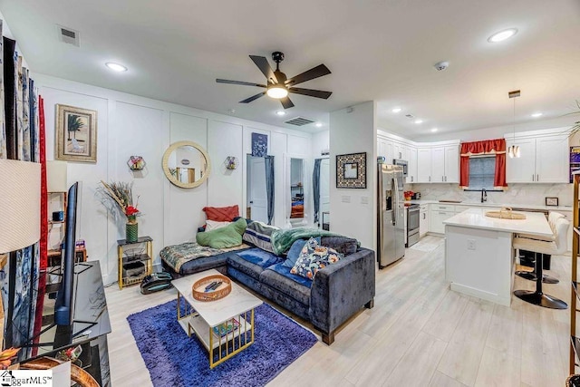 living room featuring sink and ceiling fan