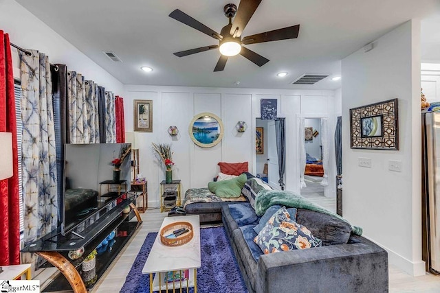 living room featuring ceiling fan and light hardwood / wood-style flooring