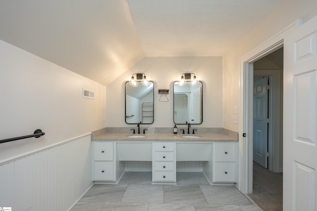 bathroom with vaulted ceiling and vanity