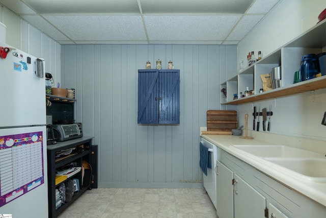 kitchen featuring sink, white appliances, a paneled ceiling, and white cabinets