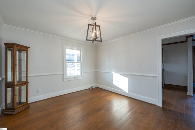 spare room featuring an inviting chandelier, ornamental molding, and dark hardwood / wood-style floors