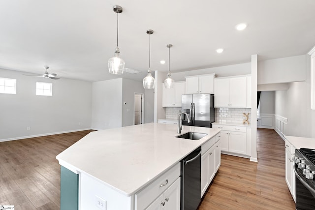 kitchen featuring sink, white cabinets, a kitchen island with sink, and stainless steel appliances