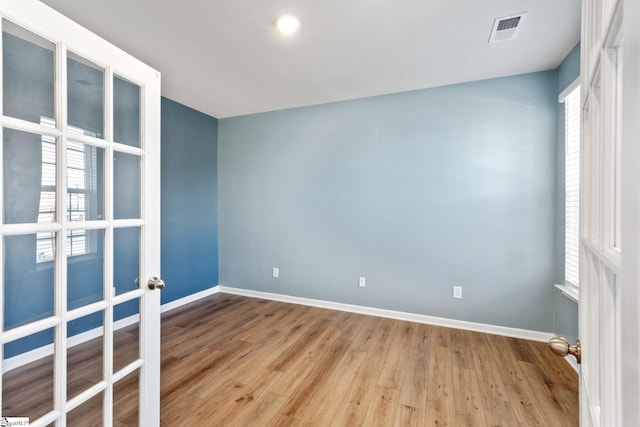 empty room with light hardwood / wood-style flooring and french doors