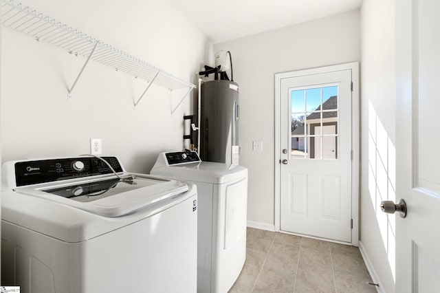 washroom with light tile patterned floors, washing machine and dryer, and electric water heater