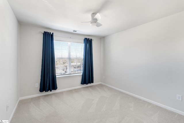 carpeted spare room featuring ceiling fan