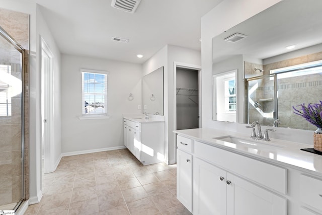 bathroom featuring tile patterned floors, walk in shower, a healthy amount of sunlight, and vanity