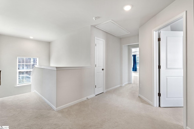 hallway featuring light colored carpet and a wealth of natural light