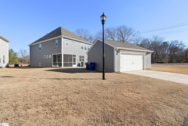 exterior space with an outdoor structure, a lawn, a garage, and a sunroom