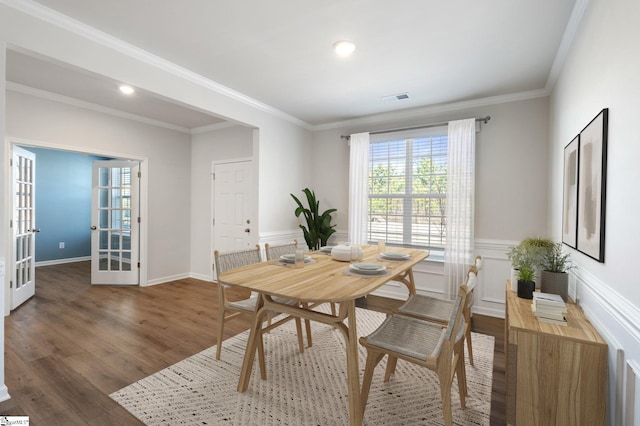 dining space with french doors, ornamental molding, and dark wood-type flooring