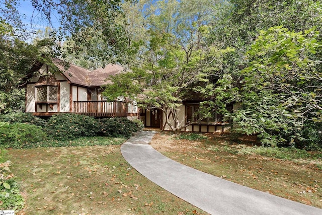 view of front of home featuring a wooden deck and a front lawn