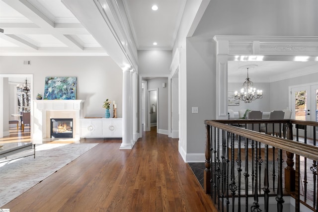 corridor featuring coffered ceiling, beam ceiling, a notable chandelier, and ornamental molding