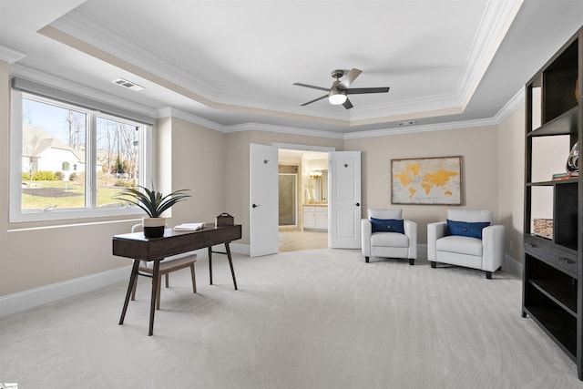 carpeted home office featuring ceiling fan, crown molding, and a raised ceiling