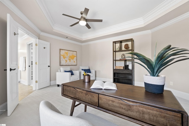 carpeted office space featuring ceiling fan, a raised ceiling, and crown molding