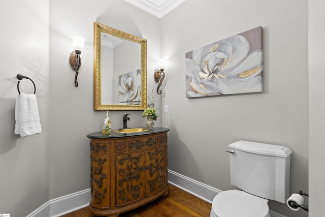 bathroom featuring hardwood / wood-style flooring, toilet, vanity, and ornamental molding