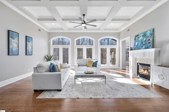 living room featuring crown molding, coffered ceiling, hardwood / wood-style floors, and beam ceiling