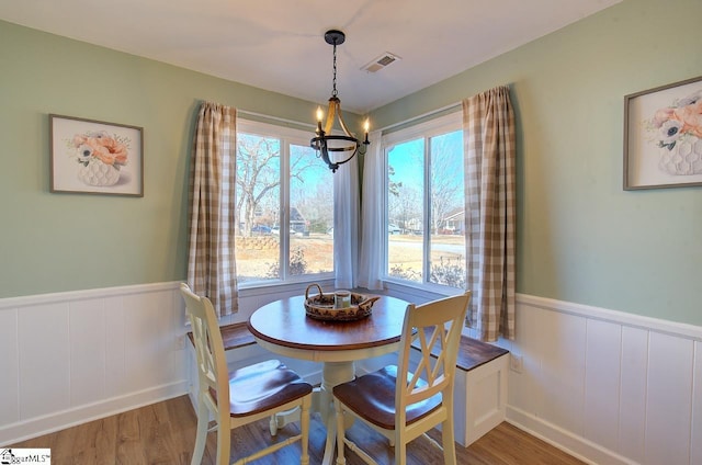 dining room featuring plenty of natural light, wood-type flooring, and a chandelier