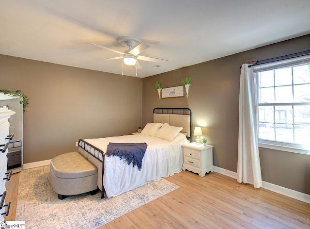 bedroom with light wood-type flooring, multiple windows, and ceiling fan