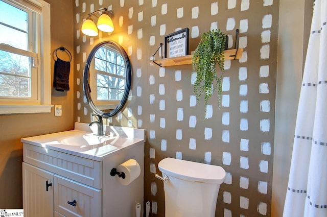 bathroom with vanity, toilet, and a healthy amount of sunlight