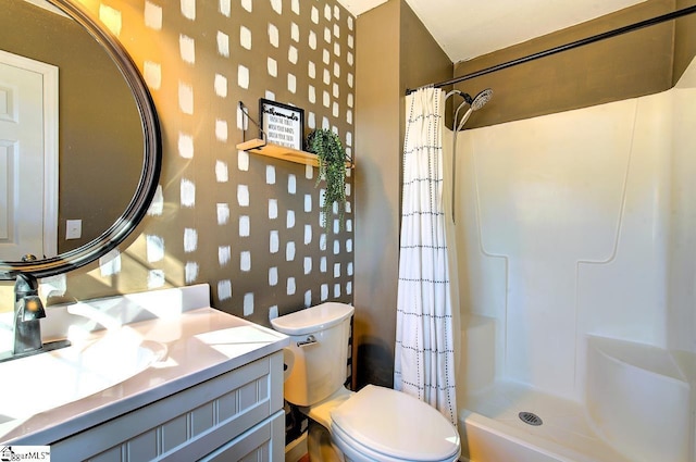 bathroom featuring toilet, vanity, and a shower with curtain