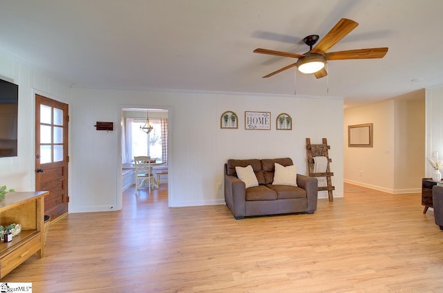 living room with ornamental molding, ceiling fan, and light hardwood / wood-style flooring