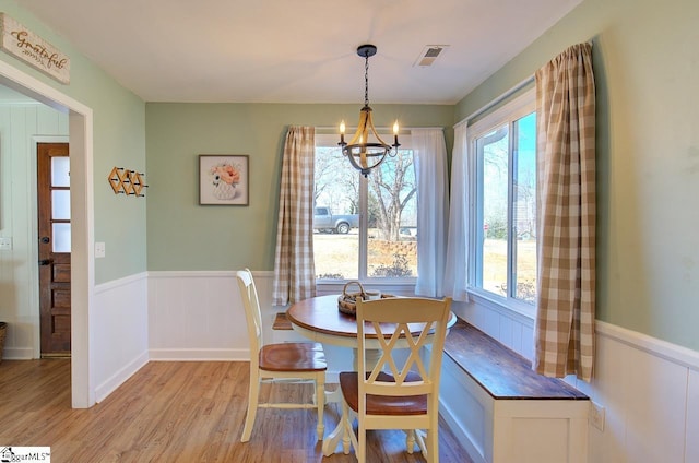 dining space featuring light hardwood / wood-style floors and a chandelier