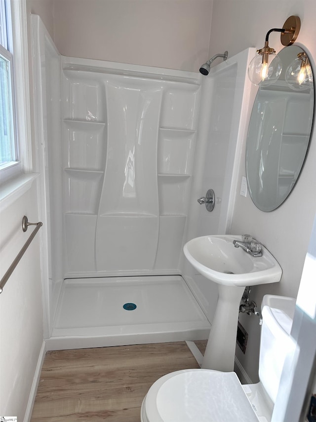 bathroom featuring walk in shower, toilet, and hardwood / wood-style flooring