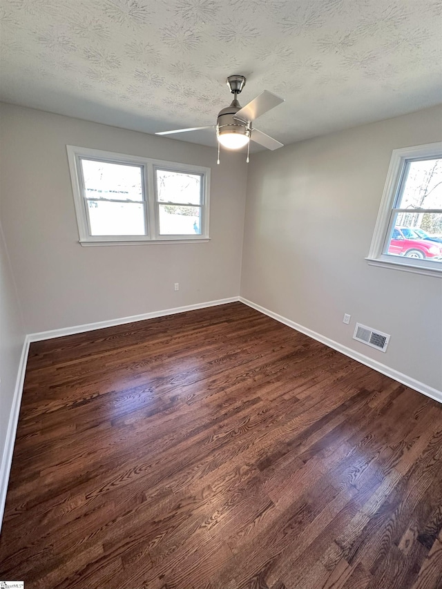 spare room featuring ceiling fan, dark hardwood / wood-style floors, and a textured ceiling