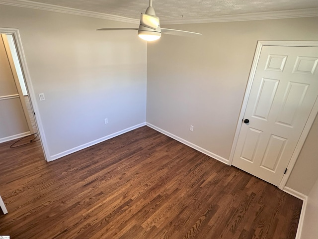 empty room with crown molding, dark hardwood / wood-style floors, and ceiling fan