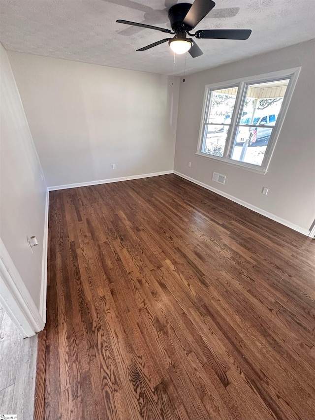 spare room featuring ceiling fan, a textured ceiling, and dark hardwood / wood-style flooring