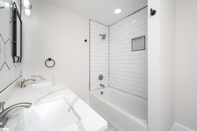 bathroom featuring vanity and tiled shower / bath