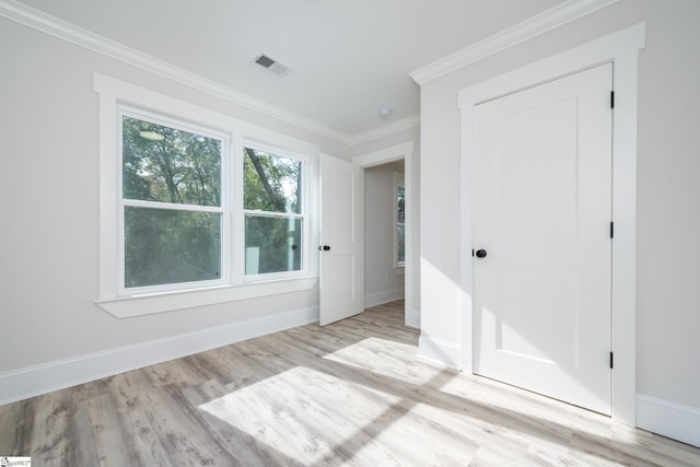 spare room featuring crown molding and light wood-type flooring