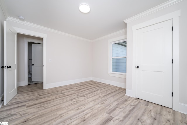 empty room featuring light hardwood / wood-style flooring and ornamental molding