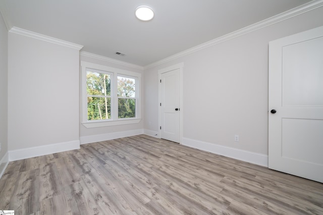 spare room featuring light hardwood / wood-style flooring and crown molding