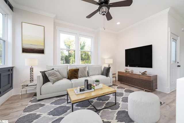 living room with light wood finished floors, baseboards, and crown molding