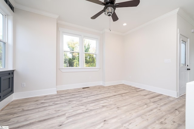 empty room with light wood finished floors, ornamental molding, visible vents, and baseboards