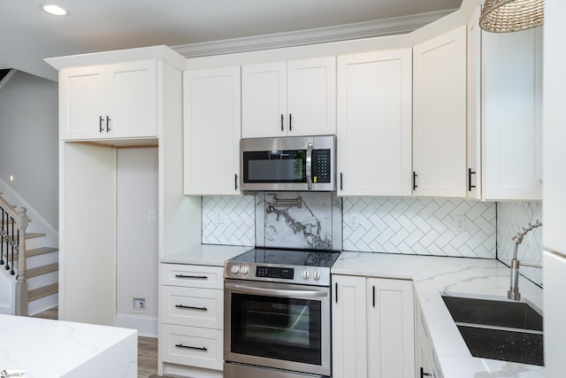 kitchen featuring light stone counters, white cabinets, and stainless steel appliances