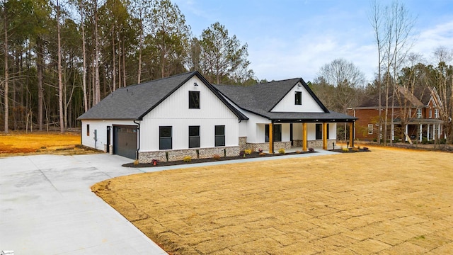 modern farmhouse with a porch, a garage, and a front yard