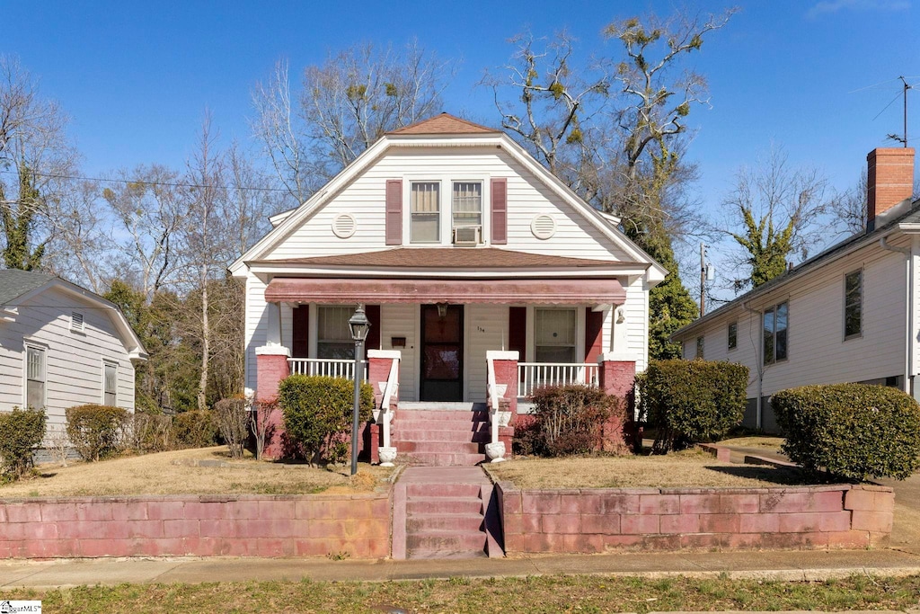 view of front of home with a front yard and a porch