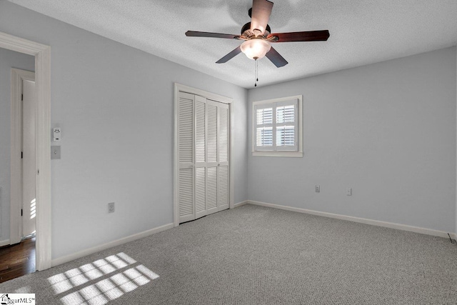 unfurnished bedroom featuring ceiling fan, a textured ceiling, a closet, and carpet floors