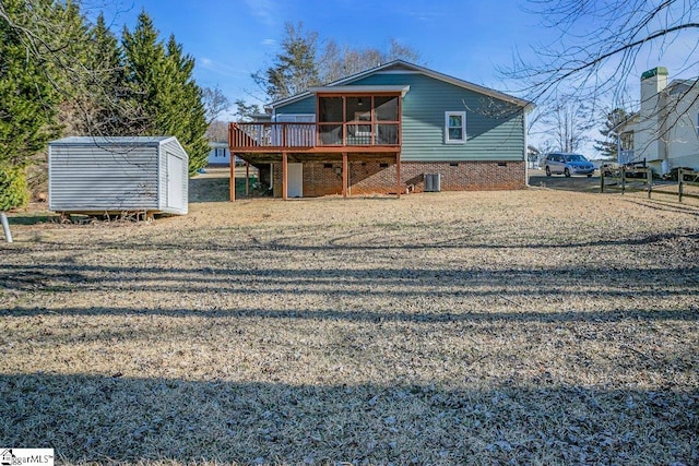 back of house with a deck, cooling unit, a sunroom, and a shed