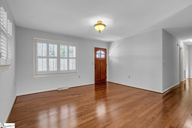 foyer entrance featuring hardwood / wood-style floors, a healthy amount of sunlight, and a textured ceiling