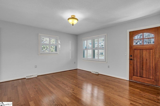 foyer featuring wood-type flooring and a textured ceiling