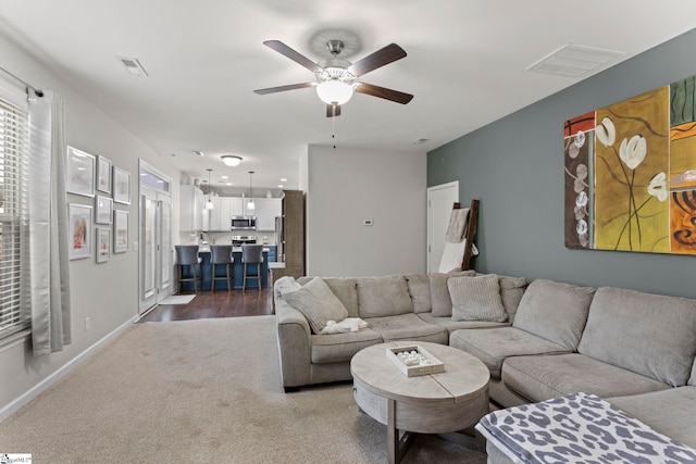 living room with ceiling fan and carpet