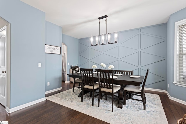 dining space with a notable chandelier and dark hardwood / wood-style floors