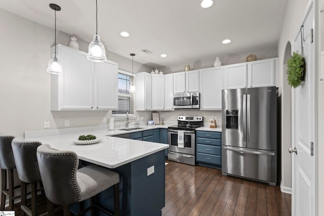 kitchen with white cabinetry, sink, pendant lighting, and stainless steel appliances