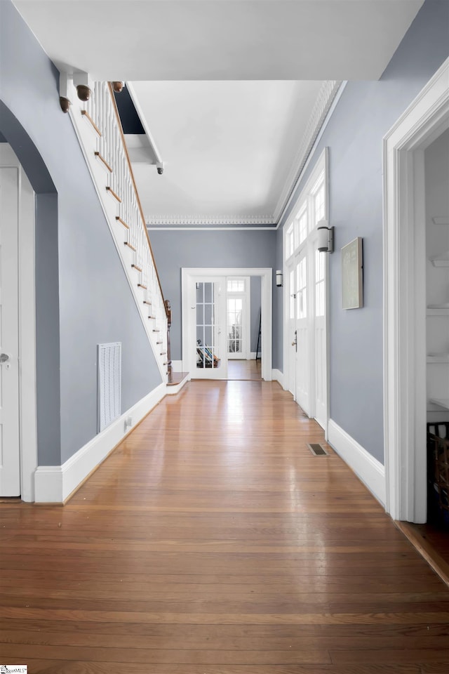 foyer entrance with hardwood / wood-style flooring and ornamental molding