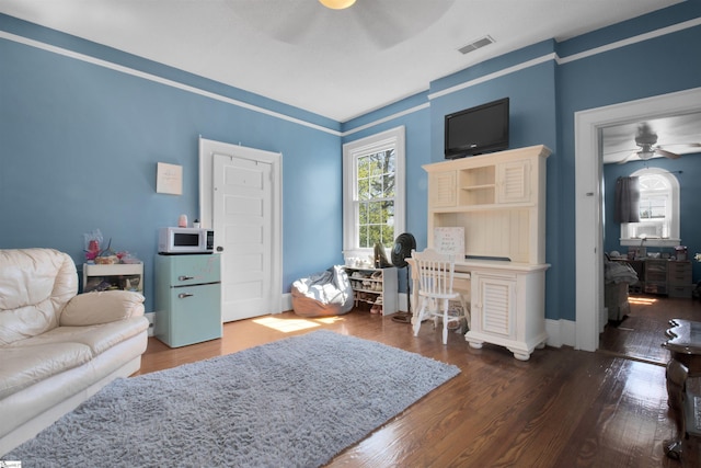 living room with ceiling fan and dark wood-type flooring