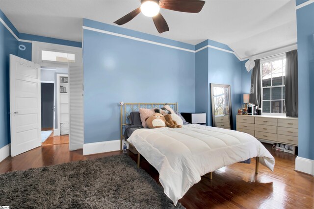 bedroom with ceiling fan, dark hardwood / wood-style floors, and vaulted ceiling