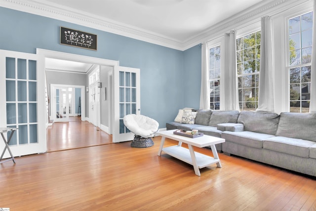 living room featuring light wood-type flooring, french doors, and ornamental molding